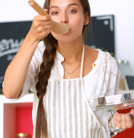 Cooking woman in kitchen with wooden spoonの写真素材