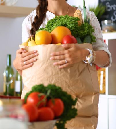 Young woman holding grocery shopping bag with vegetablesの写真素材