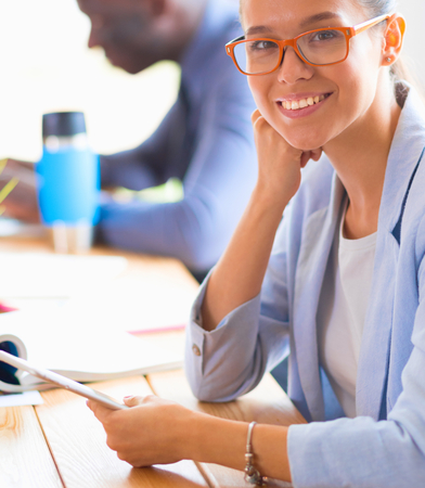 Business woman sitting in her office using a tablet computerの写真素材