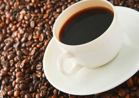Cup of coffee on beans as background.の写真素材