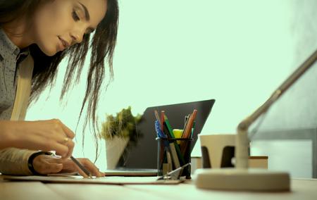 Young female working sitting at a desk.の写真素材