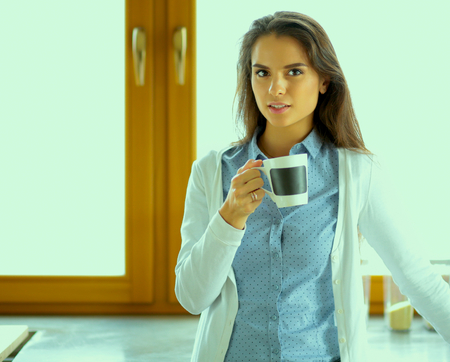 happy woman drinking tea in the kitchen at home.の写真素材