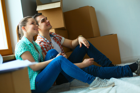 Couple moving in house sitting on the floor.の写真素材