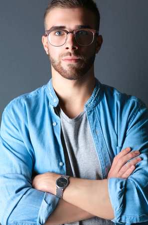 Portrait of a happy casual man standing isolated on a dark backgroundの写真素材