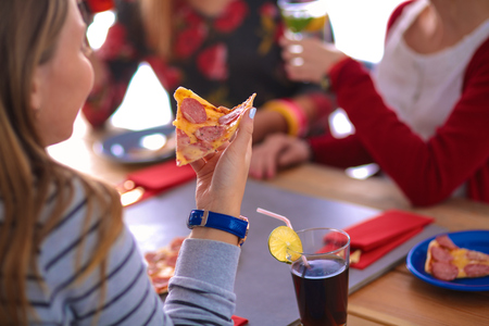 Beautiful young woman eating a slice of pizza.の写真素材
