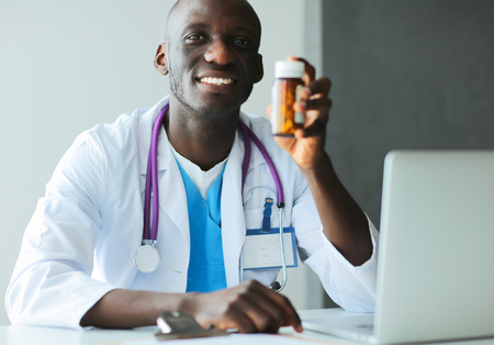 Close-up of male doctor giving jar of pills to patient.の写真素材