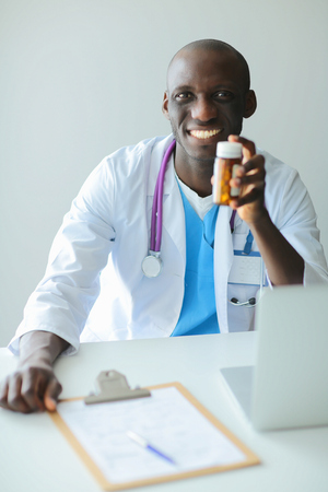 Close-up of male doctor giving jar of pills to patient.の写真素材