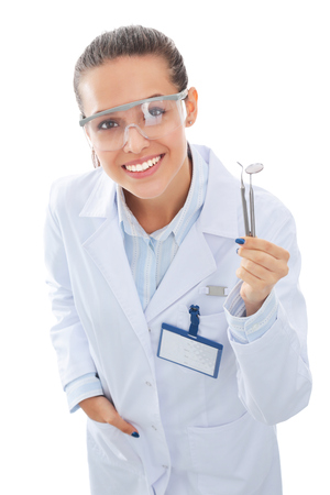 Beautiful female dentist doctor holding and showing toothbrush isolated on a white background.の写真素材