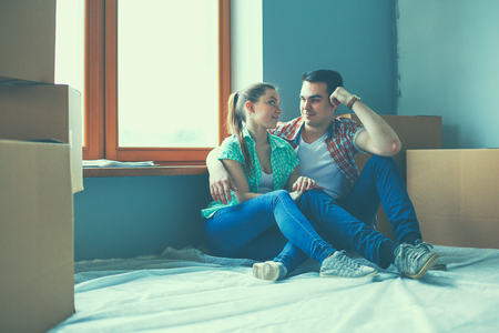Couple moving in house sitting on the floor.の写真素材