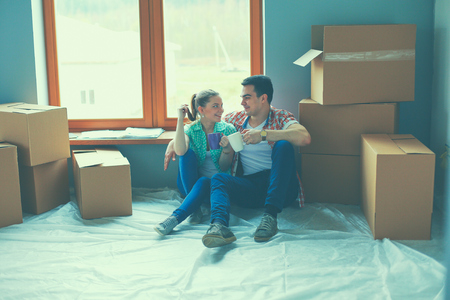 Couple moving in house sitting on the floor.の写真素材