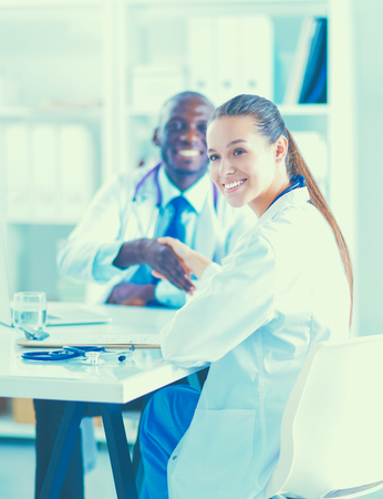 Two happy smiling young medical people handshaking at office.の写真素材
