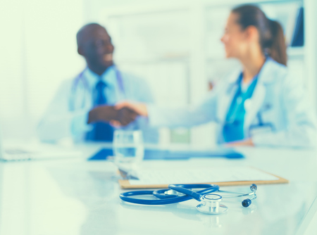 Stethoscope on the desk and young medical people as background.の写真素材