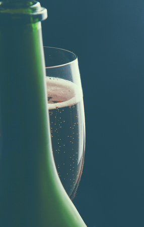 A glass of wine and a bottle on black background.の写真素材
