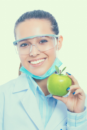 Smiling woman doctor with a green apple.の写真素材