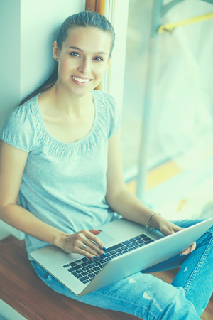 Young beautiful woman using a laptop computer at home.の写真素材