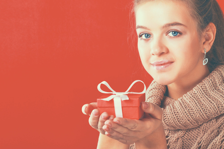 A young woman is standing while holding a bag of gifts over her shoulder .の写真素材