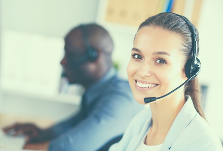 Business people with headsets using computers in office.の写真素材