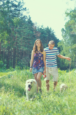 Young couple walking dog on the nature.の写真素材