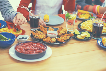 Group of people having dinner together while sitting at wooden table.の写真素材