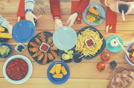 Top view of group of people having dinner together while sitting at wooden tableの写真素材