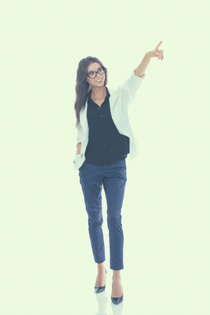 Portrait of a smiling young woman pointing up, isolated on white background.の写真素材