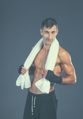 Strong athletic man standing on black background.の写真素材