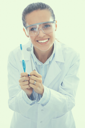 Beautiful female dentist doctor holding and showing toothbrush isolated on a white background.の写真素材