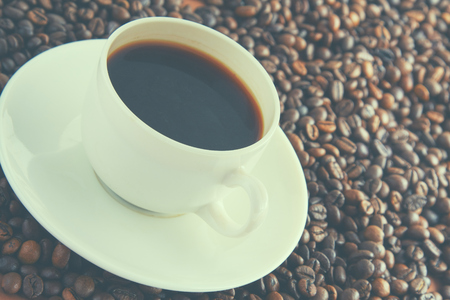 Cup of coffee on beans as background.の写真素材
