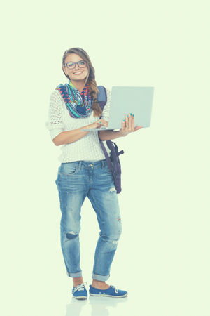 Smiling teenager with laptop on white background.の写真素材
