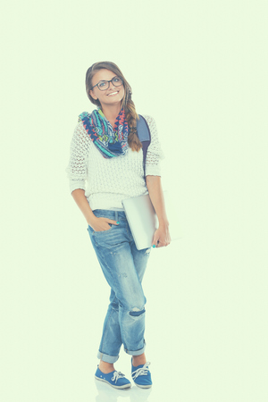 Smiling teenager with laptop on white background.の写真素材