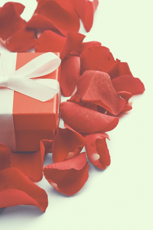 Gift box and red rose petals isolated on white background.の写真素材
