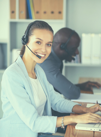 Business people with headsets using computers in office.の写真素材