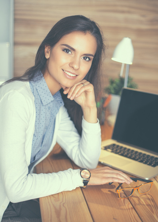 Young female working sitting at a desk.の写真素材