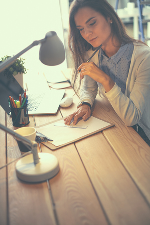 Young female working sitting at a desk.の写真素材