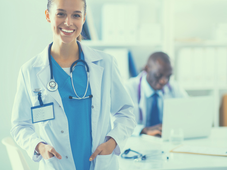 A smiling female doctor with a folder in uniform indoors.の写真素材