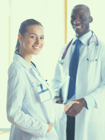 Two happy smiling young medical people handshaking at office.の写真素材