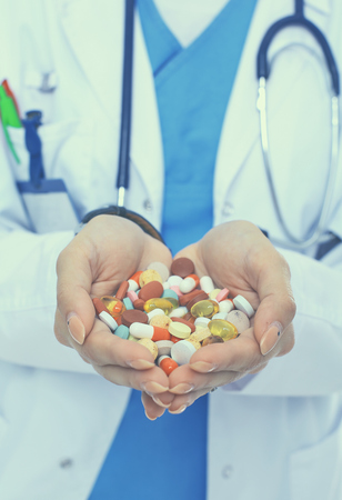 Doctor holding heap of drugs in a hand.の写真素材
