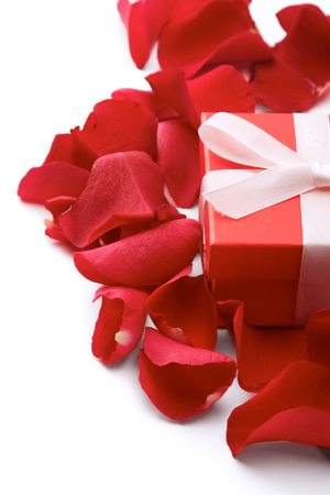 Gift box and red rose petals isolated on white background.の写真素材