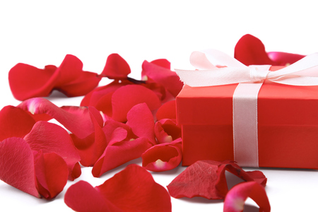 Gift box and red rose petals isolated on white background.の写真素材