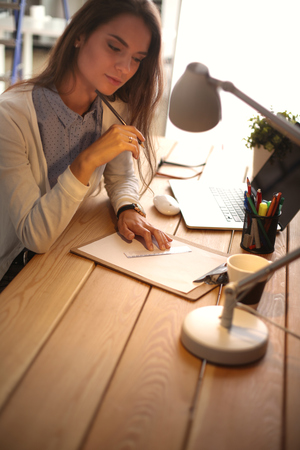 Young female working sitting at a deskの写真素材