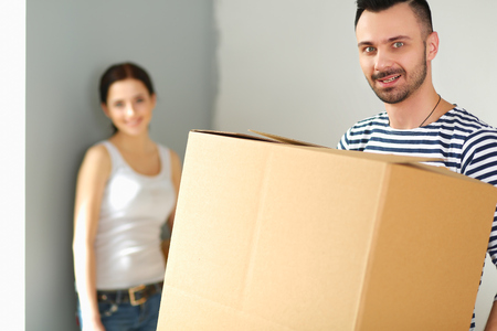 Happy young couple unpacking or packing boxes and moving into a new homeの写真素材