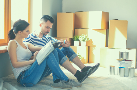 Couple moving in house sitting on the floor.の写真素材
