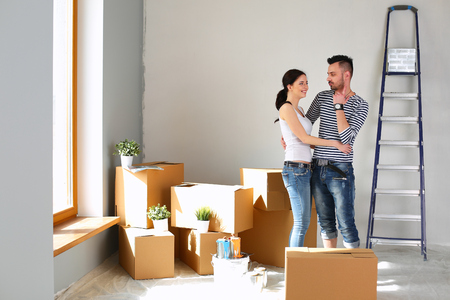Happy young couple unpacking or packing boxes and moving into a new homeの写真素材