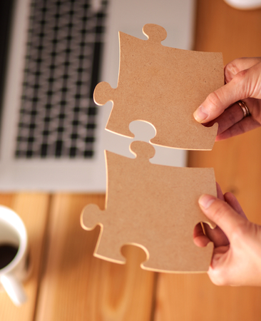 Business woman holding and pointing to a puzzle pieceの写真素材