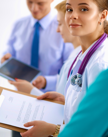 Beautiful young smiling female doctor sitting at the deskの写真素材