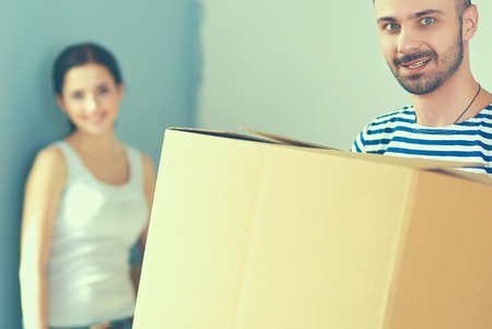 Happy young couple unpacking or packing boxes and moving into a new homeの写真素材