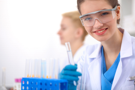 Woman researcher is surrounded by medical vials and flasks, isolated on white backgroundの写真素材