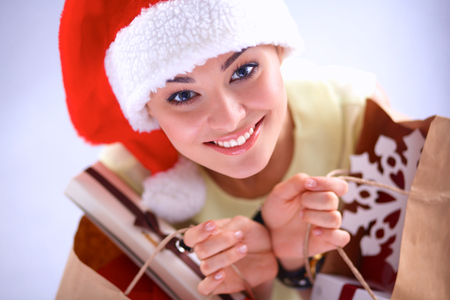 Smiling woman in santa hat with many gift boxes on white backgroundの写真素材
