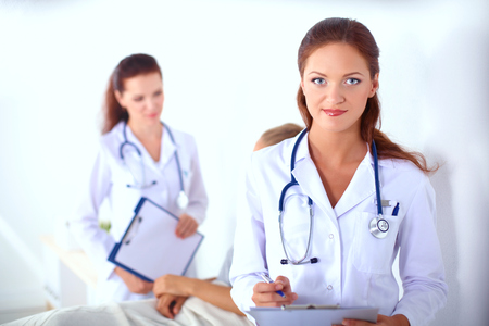 Woman doctor with folder standing at hospitalの写真素材