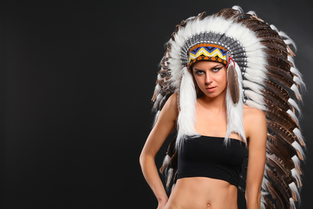 Beautiful woman in native american costume with feathersの写真素材